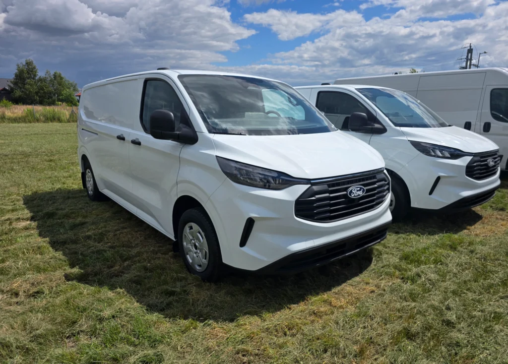 Nowy biały samochód dostawczy Ford Transit Custom furgon zaparkowany na trawie